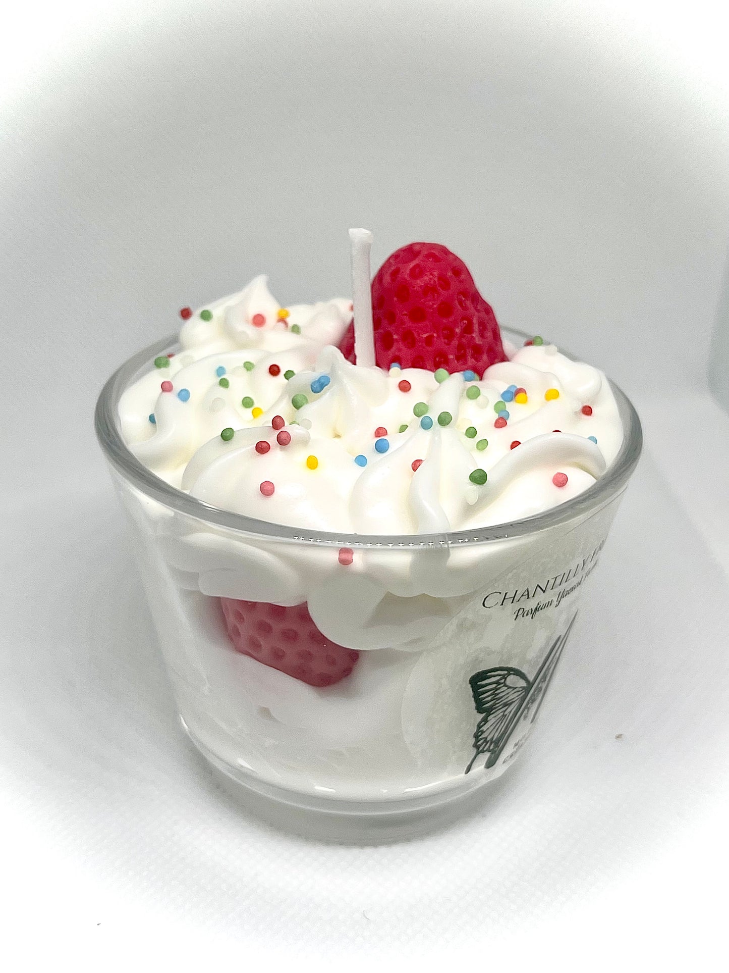 Détail bougie parfumée yaourt fraise avec texture chantilly réaliste et fraise