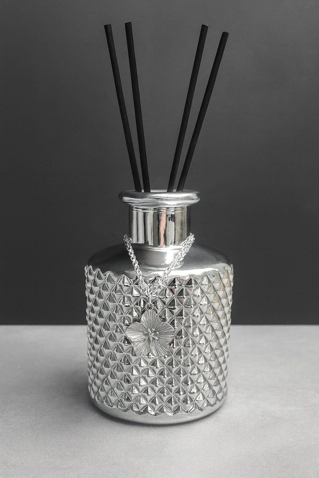 Détail diffuseur élégance argentée avec relief géométrique et chaîne