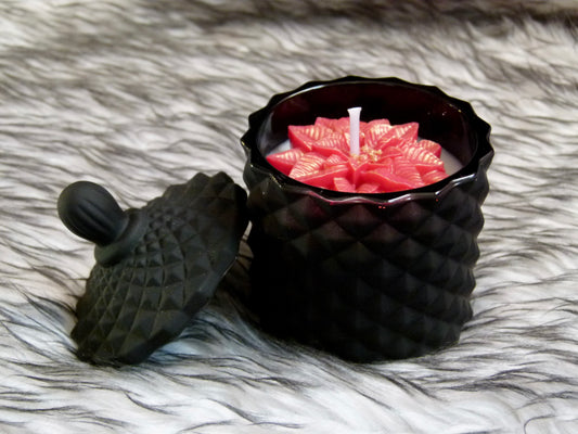 Détail bougie Noël noire texturée avec fleur poinsettia rouge et or scintillant
