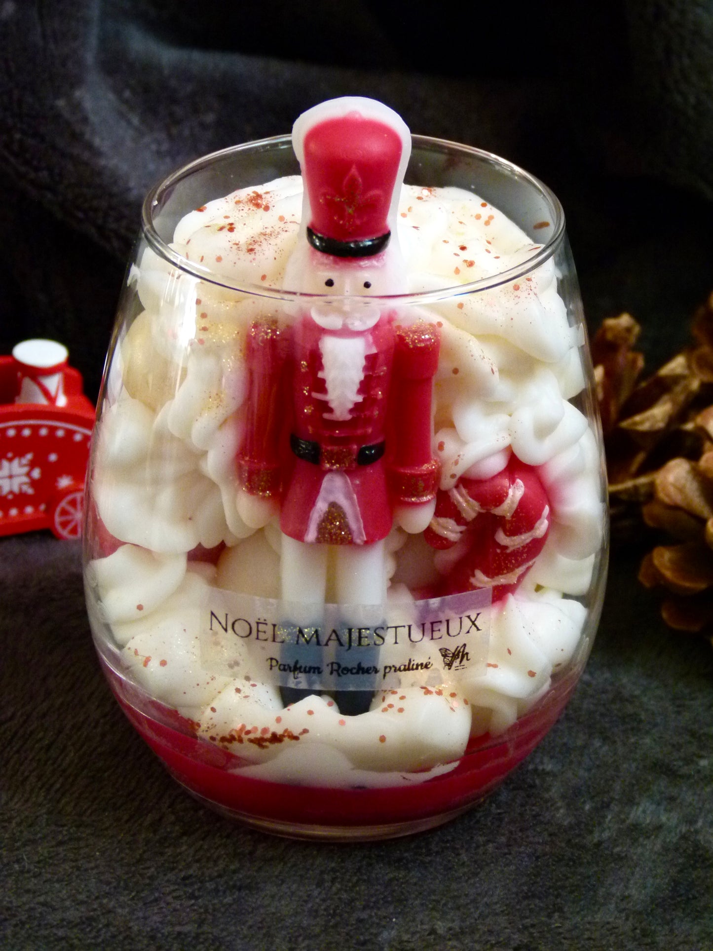 Bougie artisanale Casse-Noisette parfum rocher praliné boules de Noël rouge et blanc